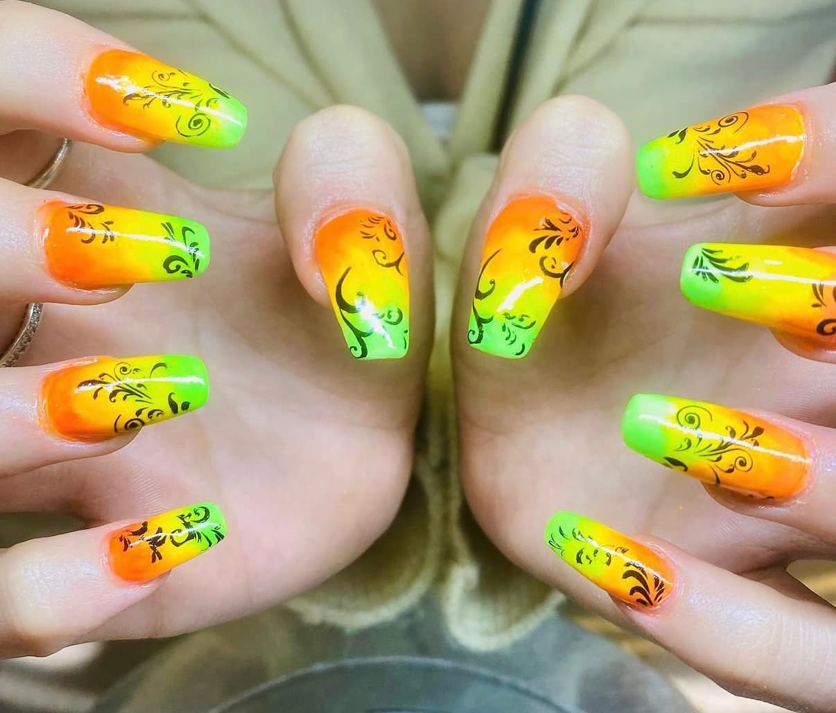 Neon orange, yellow and green ombre nails with black scrollwork