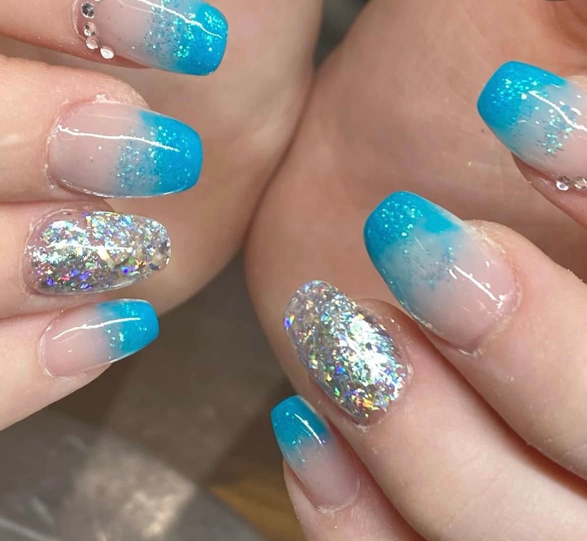 Turquoise glitter tips with silver glitter accent nails and rhinestones